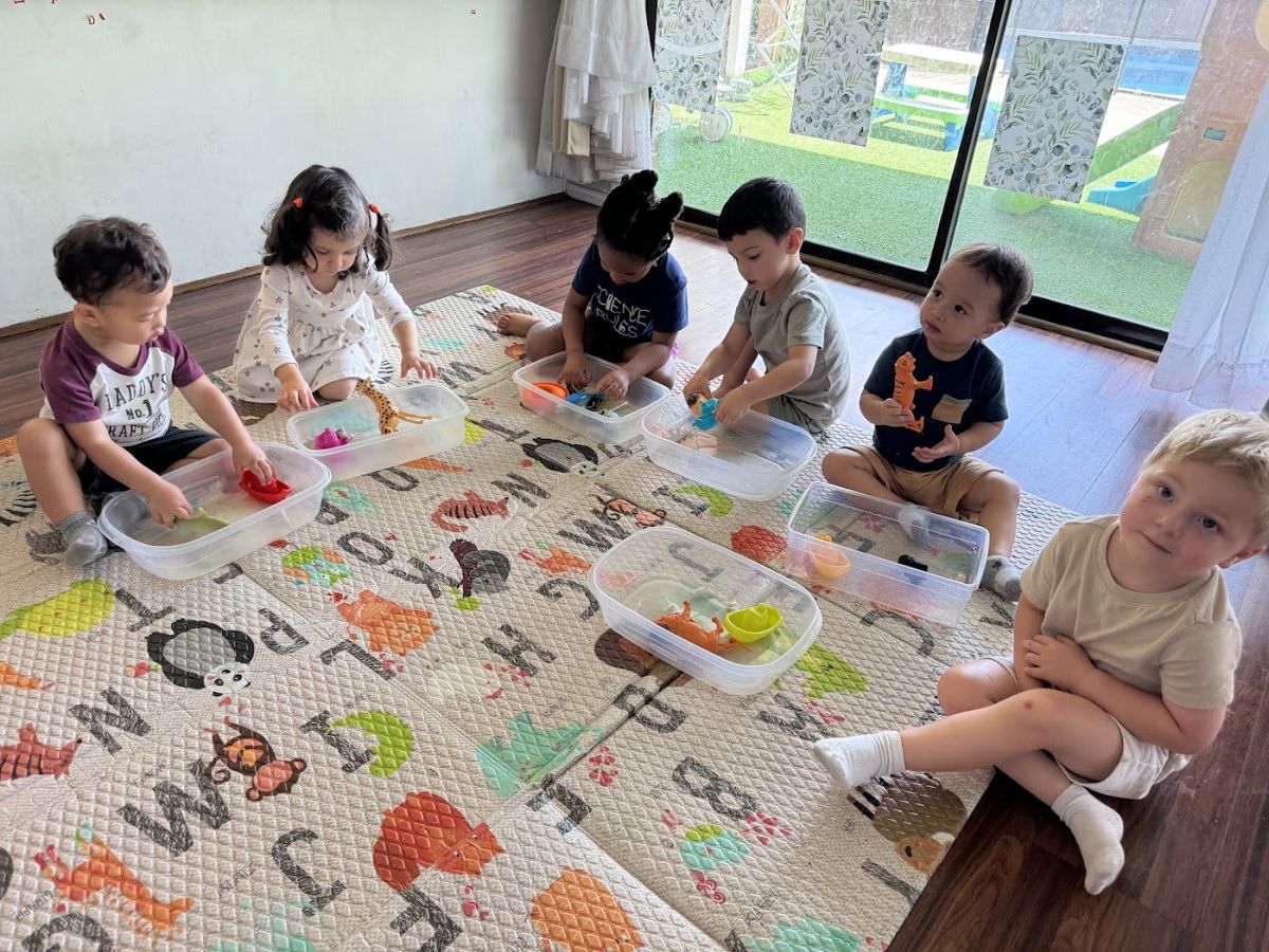 Children sitting together on the alphabet play mat